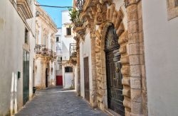 Una strada nel centro di Martina Franca, Puglia. Ad impreziosire la parte vecchia della città sono le caratteristiche casette bianche che si sviluppano in verticale e si dipanano in stradine ...