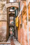 Una strada stretta nel centro medievale di Albenga, Liguria. Da notare la pavimentazione ciottolata tipica di queste località liguri.



