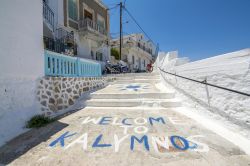 Una stradina con gradini in pietra e la scritta di benvenuto sull'isola di Kalymnos, Grecia.



