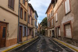 Una stradina del centro di Rabastens, valle del Tarn, Francia: sullo sfondo la  chiesa di Notre-Dame du Bourg, patrimonio dell'umanità dell'Unesco dal 1998.



