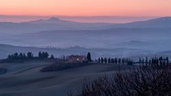 Una suggestiva alba sulle colline toscane fra San Quirico d'Orcia e la Rocca di Radicofani, Siena.
