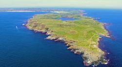 Una suggestiva veduta panoramica dall'alto dell'isola di Rathlin, Irlanda del Nord. In primo piano, il faro dell'isola.



