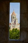 Una suggestiva vista panoramica dell'abbazia di Lerino, isola di Saint Honorat, Francia. Attraverso la feritoia di un muro in pietra, si può ammirare la torre della chiesa.

