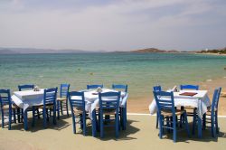 Taverna greca sul mare a Naxos, Grecia - Tavoli e sedie di un tipico ristorante greco che si affaccia sull'Egeo: nelle trattorie di Naxos, come in tutte quelle della Grecia, si possono assaporare ...