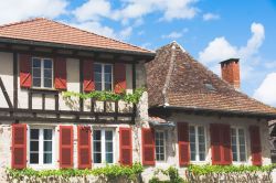 Una tipica casa nel villaggio medievale di Beaulieu-sur-Dordogne, Francia, con le ante delle finestre dipinte di rosso  - © Flavia Costadoni / Shutterstock.com
