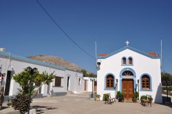 Una tipica chiesa bianca e blu sull'isola di Pserimos, Grecia, in una giornata di sole.
