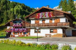 Una tradizionale casa di montagna con i fiori al balcone, Cortina d'Ampezzo, Dolomiti, Veneto.


