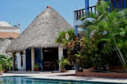 Una tradizionale palapa messicana con il tetto in paglia a Puerto Escondido: siamo in un hotel con piscina - © lovemydesigns / Shutterstock.com