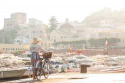 Una turista in bicicletta al porto di Ponza, Isole Pontine, Lazio.