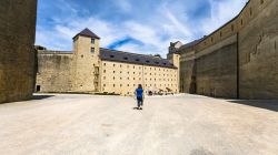 Una turista nel cortile del castello di Sedan, Ardenne, in una giornata estiva (Francia) - © vvoe / Shutterstock.com