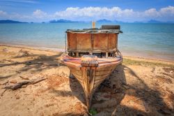 Una vecchia barca in legno sulla spiaggia di Koh Yao Noi, Thailandia. Quest'isola è circondata per lo più da spiagge deserte perchè connesse alla strada principale da ...
