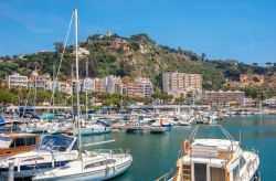 Una veduta del porto di Blanes con gli yachts ormeggiati e le montagne di Sant Joan sullo sfondo, Costa Brava, Spagna.
