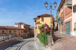 Una viuzza con lampione nella cittadina di La Morra, Cuneo, Piemonte. Ad affacciarsi su questi stretti vicoli sono delle belle case dalle facciate tinteggiate con colori pastello 
