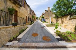 Una viuzza nel vecchio villaggio di Domme, Dordogna, Francia. Il suo pittoresco aspetto medievale accompagna i visitatori in un viaggio nel passato alla scoperta di un reticolo di strade intrise ...