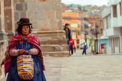 Un'anziana donna peruviana in abiti tipici sotto l'arco di Deustua a Puno, Perù - © Simon Mayer / Shutterstock.com