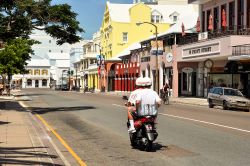 Uno scooter con due turisti in tour per una strada vuota a Hamilton, Bermuda. Siamo in una delle più piccole capitali di stato al mondo - © Andres Virviescas / Shutterstock.com