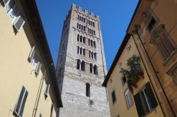 Uno scorcio del campanile del duomo di Lucca, Toscana. La torre campanaria a base quadrangolare si presenta con 5 ordini di polifore e termina con decorazione a merli ghibellini. L'interno ...