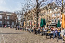 Uno scorcio del centro storico di Den Haag con gente seduta ai bar all'aperto (Olanda). Siamo nella terza più grande città del paese - © Photos by D / Shutterstock.com ...