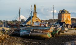 Uno scorcio del porto di Camaret-sur-Mer in Bretagna, Francia. Nella foto, relitti di barche per la pesca delle aragoste con sullo sfondo due monumenti storici della città, la Torre Vauban ...