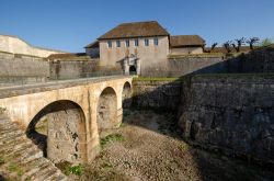 Uno scorcio della cittadella di Besancon, Francia: un ponte in pietra attraversa un alto fossato.

