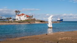 Uno scorcio di Famagosta, Cipro Nord: una bella casa, una nave abbandonata e un monumento ai delfini.

