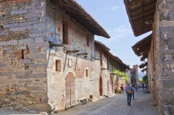 Uno scorcio fotografico di Ricetto di Candelo, Biella, Piemonte. Turisti in visita al borgo passeggiano per le vie dai grandi ciottoli inclinati.
