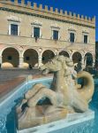 Uno scorcio panoramico di Piazza del Popolo a Pesaro con la fontana e il Palazzo Ducale sullo sfondo, Marche, Italia.
