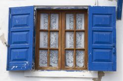 Una tradizionale finestra greca sull'isola di Ai Stratis, Grecia. Come le porte d'ingresso, anche finestre e balconi sono dipinti nelle tonalità del blu.
