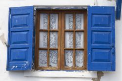 Una tradizionale finestra greca sull'isola di Ai Stratis, Grecia. Come le porte d'ingresso, anche finestre e balconi sono dipinti nelle tonalità del blu.
