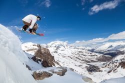 Uno snowboarder si esibisce in un salto su una pista del resort di Tignes, Savoia, Francia.



