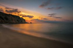Uno splendido tramonto a Porto Paglia, Gonnesa, Sardegna: i colori del cielo si riflettono sulle acque che lambiscono questa grande distesa di sabbia ambrata. 

