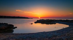 Uno splendido tramonto sul litorale dell'isola di Antiparos, Grecia. Questo territorio delle Cicladi è riuscito nel corso dei secoli a mantenere intatto il suo spirito più ...