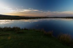 Uno stagno blu fotografato al calar del sole a Abergavenny, Galles, UK. Una bella veduta dello specchio d'acqua da Blorenge, una montagna nel sud est del Galles.

