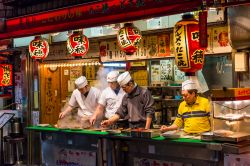 Uomini preparano il tradizionale cibo da strada in una via di Osaka, Giappone - © Joshua Davenport / Shutterstock.com