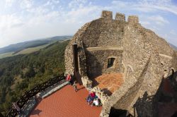 Turisti in visita alle mura fortificate del castello di Holloko, Ungheria. Da qui si gode un magnifico panorama dell'area protetta del Parco Nazionale di Bukk - © GTS Productions / ...