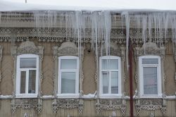 Una vecchia abitazione in legno con finestre decorate, tipica di Tomsk, durante il periodo invernale - © Sergey Bezgodov / Shutterstock.com