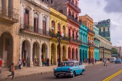 Una vecchia auto americana lungo la strada costellata di edifici coloniali, alcuni dei quali restaurati di recente, nel quartiere de La Habana Vieja (L'Avana, Cuba) - © Julian ...