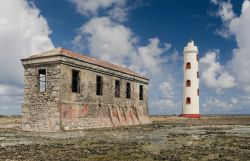 Vecchio e nuovo sulla costa nord dell'isola di Bonaire, Antille olandesi. Il moderno faro situato sul punto più orientale della costa contrasta con le vicine rovine di un edificio ...