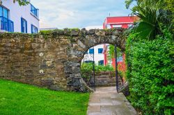 Un vecchio muro di pietra con una porta a forma di luna a Queens Park, Hamilton, Bermuda.



