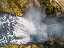 Veduta aerea della cascata di Skogafoss, Islanda. L'imponente cascata è l'ultima di una serie di 20 situate sul fiume Skogaa. L'acqua che riversa è quella proveniente ...