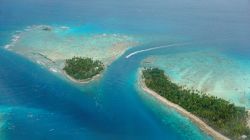 Veduta aerea di isole tropicali con la laguna e il canale a Avatoru Pass, Rangiroa, Tuamotu (Polinesia Francese).

