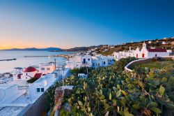 Veduta al crepuscolo della città di Mykonos e dell'isola di Tino sullo sfondo, Grecia.
