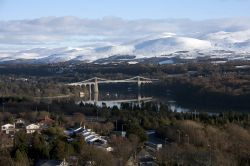 Veduta dalla Colonna Anglesey con il ponte Menai Suspension, Galles, UK. Il ponte sospeso sullo stretto di Menai collega Anglesey alla terraferma. Sullo sfondo le Snowdonian Hills coperte di ...