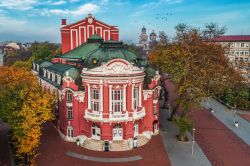Veduta dall'alto del suggestivo teatro di Varna nel centro storico, Bulgaria. L'edificio dello State Opera Varna con la caratteristica facciata rossa e i tetti e le cupole color verde ...