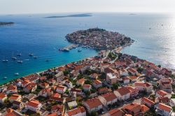 Veduta dall'elicottero di Primosten e del suo centro storico, Dalmazia, Croazia. Questa località ha conservato intatta la sua caratteristica atmosfera di borgo medievale tipico del ...