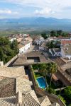 Veduta della città di Baeza dalla torre della cattedrale, Spagna: nella fotografia una piscina, i tetti delle case e i campi di ulivi.

