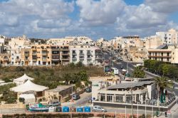 Veduta della città di Marsascala, isola di Malta: case residenziali e una strada con automobili in una giornata nuvolosa - © Yassmin Photo / Shutterstock.com