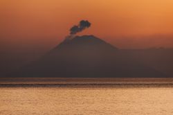 Veduta dello Stromboli da Salina, Sicilia - Una suggestiva immagine ritrae il vulcano durante un'eruzione all'alba. Lo Stromboli viene chiamato dai suoi abitanti "Struognoli" ...