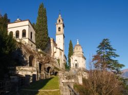 Veduta del villaggio con edifici religiosi lungo la costa ovest del lago di Como, Lombardia. Il paese con la sua bella architettura si incastra alla perfezione nel paesaggio naturale che lo ...