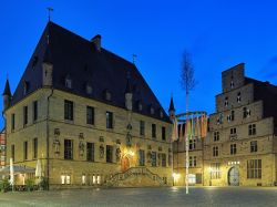 Veduta notturna della piazza del Mercato con il Municipio e la Weigh House di Osnabruck, Germania.



